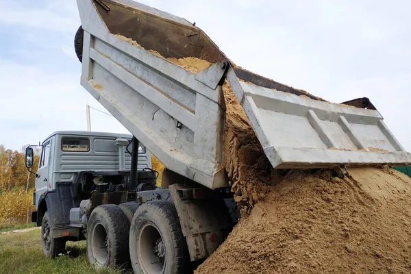 A dump truck unloads sand at a construction site to mix cement. — Stock Photo, Image
