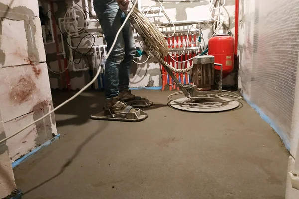 Sand-cement floor screed in a private house, the worker works with tools. — ストック写真