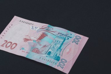 Ukrainian two hundred hryvnia lie on the back on a black isolate