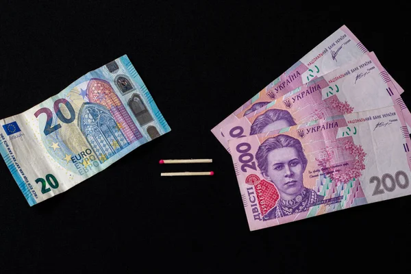 Euro en hryvnia, bankbiljetten op zwarte achtergrond. — Stockfoto