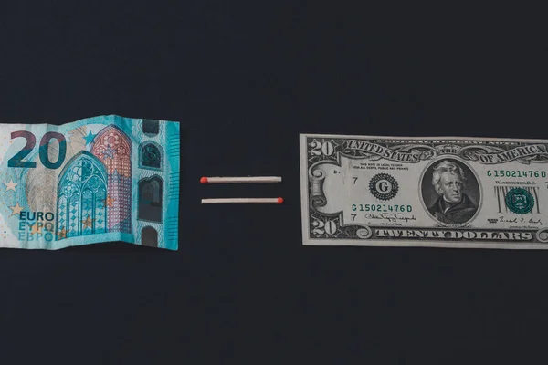 Euros and dollars on a black background, banknotes comparison. — Stok fotoğraf