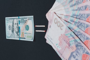 Euro and hryvnia, banknotes on black background.