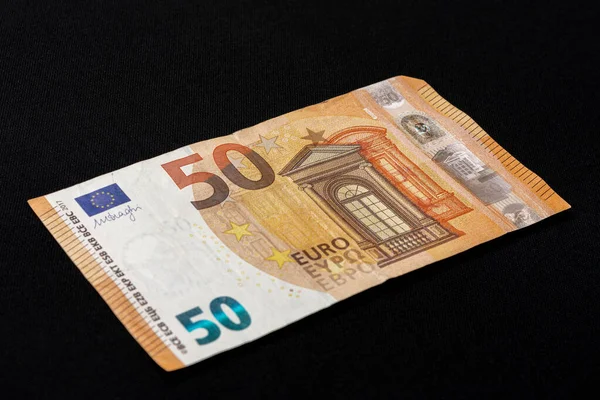Pięćdziesiąt euro denominowanych w euro papierowych pieniędzy na czarnym tle. — Zdjęcie stockowe