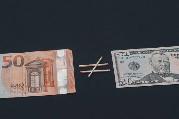 Euro non è uguale al dollaro, carta moneta su sfondo nero . — Foto Stock