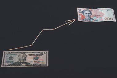 Siyah arka planda oklu Ukrayna Hryvnia ve Amerikan doları.