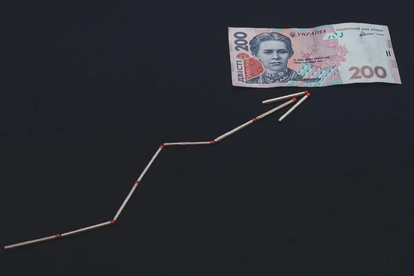 Flecha de enxofre e 200 hryvnia sobre fundo preto . — Fotografia de Stock