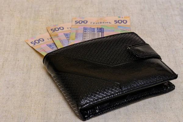 Fünfhundert ukrainische Griwna-Banknoten in schwarzer Handtasche. — Stockfoto