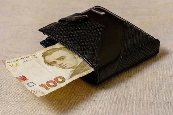 Ukrainian hryvnia in a black wallet on a gray background. — Stockfoto
