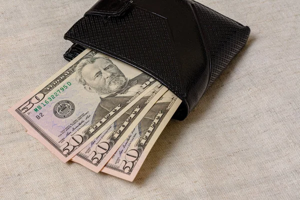 Black wallet with dollars 50 on a gray background. — Stock fotografie