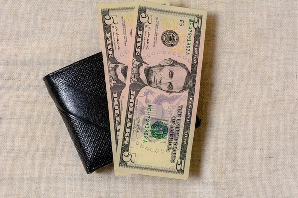 A dollar bill in the size 5 of a black wallet. — Stock fotografie
