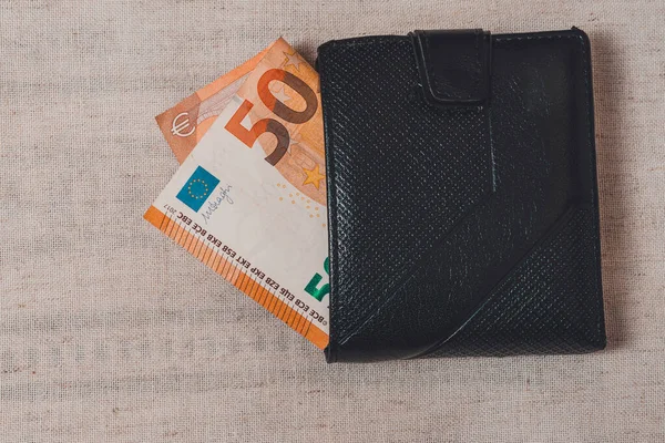Euro-Banknoten und schwarze Brieftasche auf grauem Hintergrund — Stockfoto