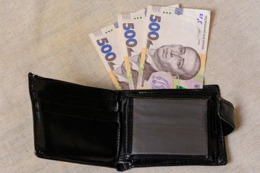 500 hryvnia in a black wallet on a gray background.