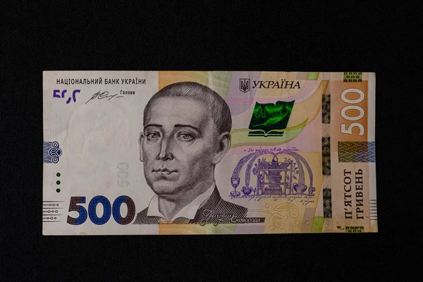 Um monte de hryvnias ucranianas, valor facial 500 hryvnias em um fundo preto, bem colocado dinheiro em preto . — Fotografia de Stock