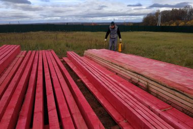 İşçi ahşap tahtaları koruyucu boyayla kaplıyor. 2020