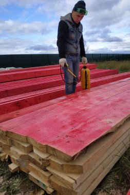 İşçi ahşap tahtaları koruyucu boyayla kaplıyor. 2020