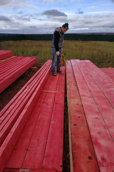 労働者は木製の板を保護塗料で覆う 2020 — ストック写真