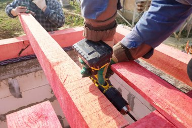 İşçiler 2020 çatısı için ahşap kirişler dikiyorlar.