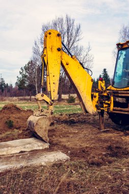 Kazıcı, özel bölgede yolu açmak için beton levhaları hareket ettiriyor. 2020