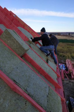 İşçi, evin ısınması için 2020 mineral yünüyle çalışmalara devam ediyor.