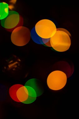 Turuncu, sarı, siyah arkaplanda açık kırmızı bokeh.