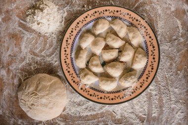 Çiğ hamur tatlısı hazırlanmak üzere bir tabağa konur..