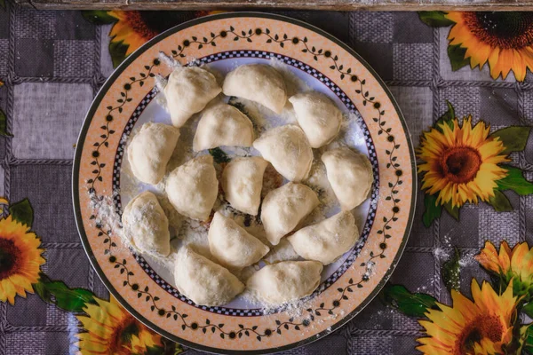Raw dumplings are laid on a prepared plate for further preparation. — Stock Photo, Image