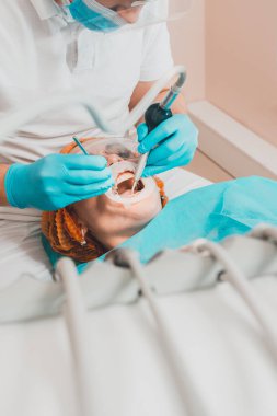 Hasta dişçide ultrasonik diş temizleme prosedürü hakkında dişçiye gider. 2020