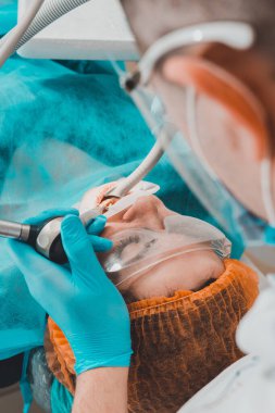 Diş hekimine yaklaşınca genç bir kadın tarı kaldırıyor. 2020