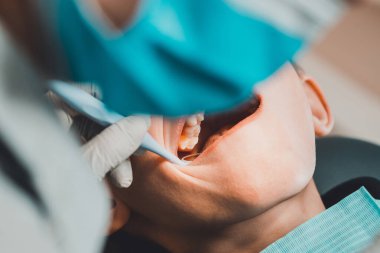 Çocuk bir ortodontist tarafından muayene edildi, ağzını iyice açtı ve dişçi dişlerini kontrol etti. 2020