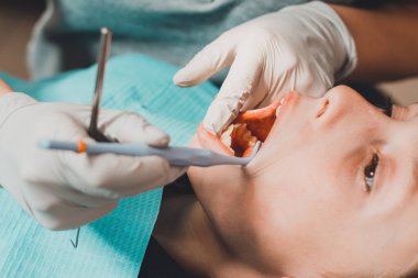 Diş muayenehanesindeki çocuk, yeni dişleri inceliyor ve kusurlu olanları tedavi ediyor. 2020