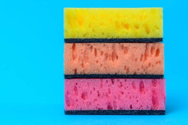 Mavi arka planda yıkama ve temizleme için süngerler. 2020