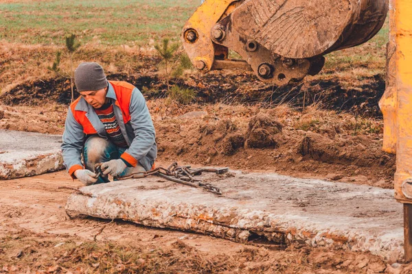 Trabalhador Desbloqueia Correntes Das Lajes Concreto Que Escavadora Carregava Com — Fotografia de Stock