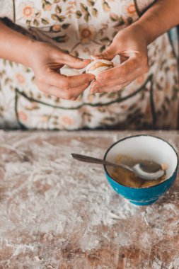 Kadın, geleneksel Ukrayna yemeklerinde beyaz arka planda patatesli hamur tatlısı veriyor. 2020