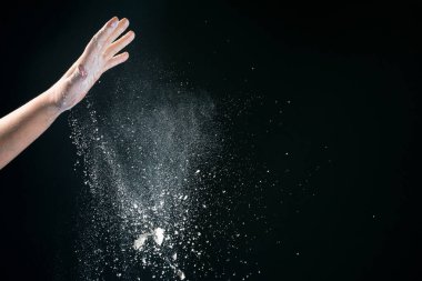 Avrupalı kadın aşçının eli mutfakta siyah arka plan 2020 'ye un döküyor.