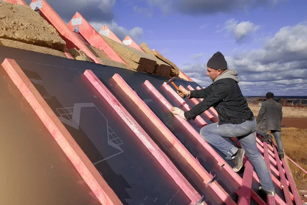 屋根表面の断熱と防水性は 労働者がボードにフィルムを爪 2020 — ストック写真