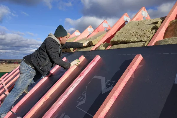 屋根表面の断熱と防水性は 労働者がボードにフィルムを爪 2020 — ストック写真