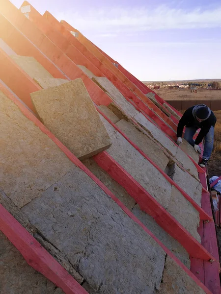 労働者は屋根の上にミネラルウールを置き 家を断熱します 2020 — ストック写真