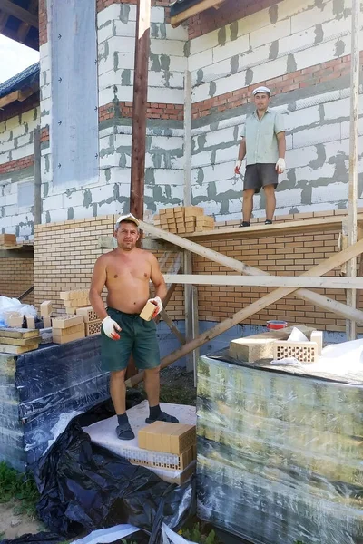 주인은 쌓는다고 인부들에게 벽돌을 던진다 2019 — 스톡 사진