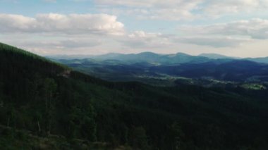 Düğün çifti üzerinde uçarken yeşil ormanlar ve mavi gökyüzü olan dağ köylerinden oluşan güzel bir manzara göreceksiniz.