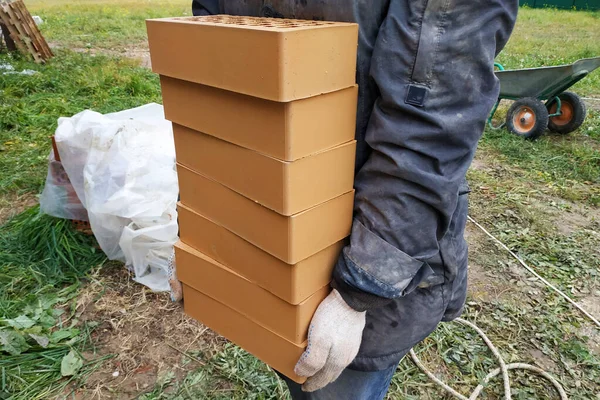 Piles Orange Bricks Stacked Rows Worker Carries Several Pieces 2020 — Stok fotoğraf