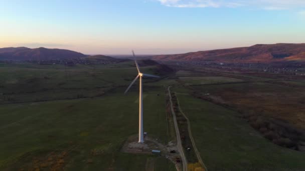 Witte eenzame windmolen draait bij zonsondergang in de bergen en produceert schone energie — Stockvideo