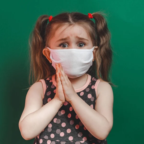 Biała Dziewczynka Masce Medycznej Podczas Epidemii Koronawirusów Modli Się Zielonym — Zdjęcie stockowe