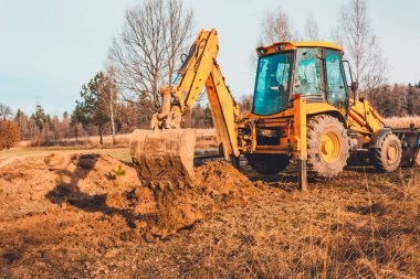 Kova kazıcı yolu açmak için toprağı topluyor. 2019