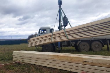 Crane, arka plandaki çatıya ahşap korkulukları indiriyor. 2020