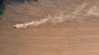 İlkbaharda ekin ekerken insansız hava aracıyla uçan bir tarlanın en üst görüntüsü. Ekonomik kriz zamanlarında bir traktör toprağı öğütücüyle öğütüyor.