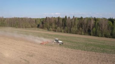 Tarımsal endüstriyel sektördeki kriz sırasında traktörün ektiği tarlanın üzerinde uçan bir uçağın yan görüntüsü
