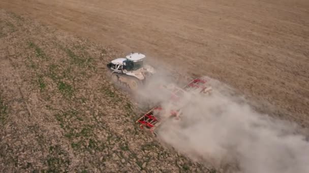 기중기를 타는 사람은 농경지에서 토양을 재배 합니다. 드론을 타고 하늘을 날 수있습니다. 4k 비디오의 편도. — 비디오