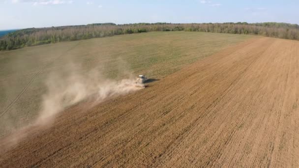 Egy kúszó traktor műveli a talajt egy mezőgazdasági területen. Top view repül egy drón. Átlós szög 4k videóban. — Stock videók