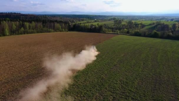 Een rupstrekker kweekt de grond in een landbouwgebied. Top uitzicht vliegen op een drone. Traceren in een cirkel. 4k video. — Stockvideo