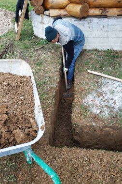 Bir işçi evin yakınında bir çukur kazıyor. 2020